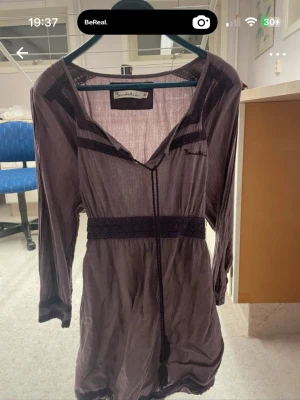 Lila klänning - Snygg lila med v-ringning och trekvartsärm. Klänningen har dekorativa spetsdetaljer och markerad midja. Perfekt för dig som gillar en avslappnad men ändå chic stil. Ingen prislapp men aldrig använd