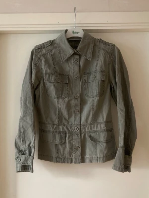 🍒Grön utilityjacka/overshirt  - 🍒UTILITY🍒Supersnygg jacka/overshirt med markerad midja, två bröstfickor med lock och slag på ärmarna och axlarna som detaljer. Kommer i ett 100% bomullstyg.🍒