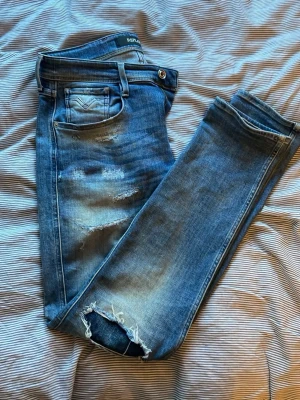 Blå slitna jeans från Replay - Säljer nu dessa riktigt feta Replay anbass jeans med slitningar✌️storlek 32/32, rätt så användna men inga defekter💯skriv om du har några frågor👌👌👊