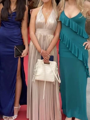 Balklänning  - Säljer min balklänning jag hade i 9an. Den är öppen i ryggen med knyten man knyter runt halsen. Bra skick. Köptes för 3000 från bubbleroom. Jag är 165 för referens. Champagne färg 