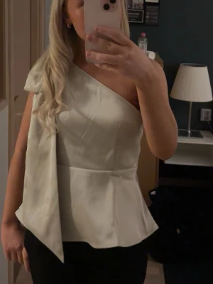 Jätte fin satin topp från hm - Satin topp från hm, köptes i november men säljer då jag inte använt den, endast en gång är den använd. I nytt skick💕jätte fin rosett på axeln också