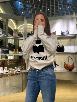 Grå sweatshirt från Isabel Marant - Cool grå sweatshirt med svart Isabel Marant-logga på bröstet. Tröjan har rund halsringning, ribbade muddar och är tillverkad i mjukt material som passar perfekt till jeans. Enkel och stilren design som är lätt att matcha. Strl 34/s