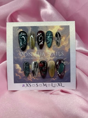 Cha-Damn (XS);Medium Almond - Handgjorda press-on naglar i mix av mörkgrön, vinröd, svart och guld med cateye detaljer, silverkjedjor och pärlor. Medium långa och mandelform för en edgy look. Perfekt för dig som vill sticka ut med konstnärlig design.XS: 14 mm, 11 mm, 11,5 mm, 10 mm, 8 mm 