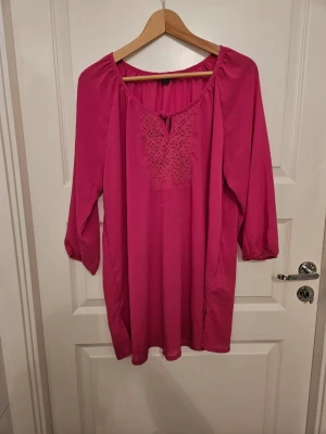 Cerise tunn tunika storlek 48 - En cerise tunn tunika med trekvartsärm i storlek 48 från Esmara Fashion i nyskick. Bröstmått 110 cm, längd 75 cm.