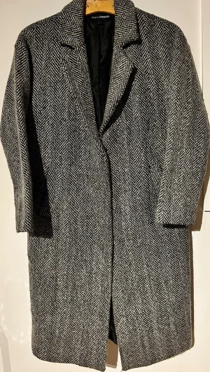 ULLKAPPA herringbone oversized S/M - SÅ snygg ullkappa i klassiskt mönster 🤍🖤 Perfekt nu till höst/vinter – går med allt.  • Oversized fit (S/M) • Rak modell = trendig • Tung & varm (48% ull)  📏 Mått: Byst 54 cm Ärm 50 cm Längd 102 cm  ✨ Bra skick