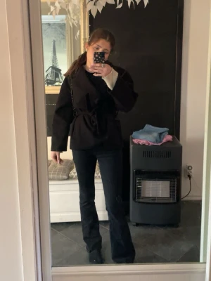 Svart kappa med knytband från missay  - Stilren svart jacka med knytband i midjan och lång ärm. Jackan har en klassisk, lite loose passform och passar perfekt till både jeans och kjol. Enkel och trendig design som funkar till många olika looks., pris kan diskuteras vid snabb o enkel affär