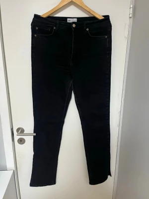 Svarta skinny jeans från Zara - Snygga svarta jeans från Zara med klassisk femficksmodell och hög midja. Jeansen har tajt material för snygg passform och smala ben. Perfekta till en avslappnad eller trendig look.