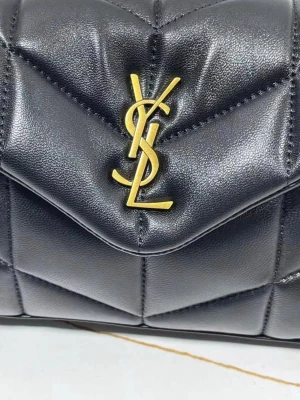 Saint Laurent Loulou Puffer - Saint Laurent Loulou Puffer i svart läder med guldfärgad YSL-logga. Väskan är i mycket fint skick och ser i princip ny ut. Storlek ca 23 × 15,5 × 5,8 cm. Originalkort och dustbag medföljer. Kvitto finns tyvärr inte kvar och därför säljer jag den till ett lägre pris. Pris: 12 500 kr men priset går att diskutera.