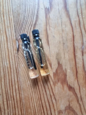 Essence prover - Två små essence parfymer genomskinliga glasflaskor med svart plastlock. Flaskorna är cylinderformade och innehåller ljusgul vätska. Perfekta att ha med i väskan eller testa en ny doft.