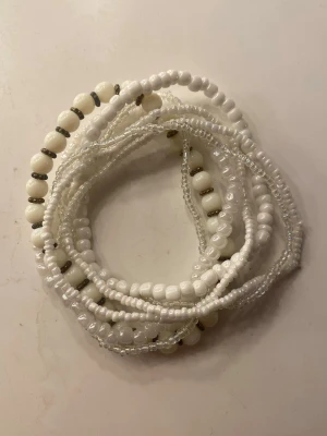 Vita pärlarmband - Säljer ett set med flera vita pärlarmband i olika stilar. Armbanden består av små vita och genomskinliga pärlor, samt ett armband med vita pärlor och silverfärgade detaljer. Perfekta att mixa och matcha för en personlig look. 10kr/st, alla 7st för 50kr🤍
