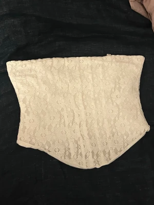 Vit spets tubtopp med blommönster - Vit tuptop i spets med blommönster. Den har en dragkedja i bak, som går att dra ner hela vägen. Toppen har ett vitt innertyg, och är inte genomskinlig💞💗Knappt använd, och har inga defekter