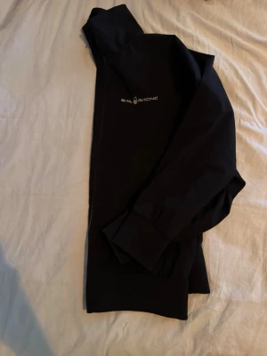 Sail Racing jacka - Snygg svart vindjacka från Sail Racing med dragkedja och diskret logga på bröstet. Jackan har långa ärmar med muddar och är tillverkad i ett lätt och vindtätt material som passar perfekt för blåsiga dagar. Priset kan diskuteras👍