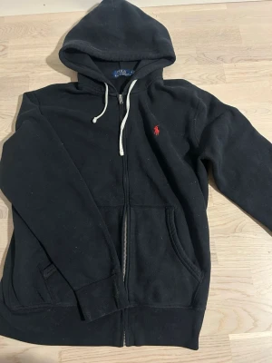 Svart hoodie från Polo Ralph Lauren - Klassisk svart hoodie med dragkedja från Polo Ralph Lauren. .