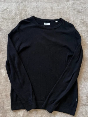 Svart stickad tröja - Säljer denna sköna stickade tröja som är en bomullsblandning. Den är i storlek M och nypris ligger på 800kr. Har en defekt som man ser på sista bilden. Syns inte vid användning för lätt att fixa bättre. Skriv vid funderingar!