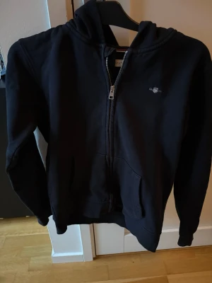 Svart Gant Zip hoodie - Mycket bra skick! Storlek 158-164 cm. Inköpspris 899 kr! Mitt pris 249 kr! Kan gå ner lite i pris vid snabb o enkel affär! Kan även köpas tillsammans med några av mina andra plagg för bättre pris! Tveka inte på att höra av er om ni har frågor!