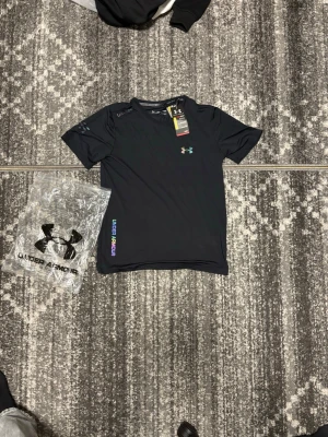 Under armour T shirt - Helt ny under armour reflektiv t shirt i svart i storlek M, perfekt för sommaren