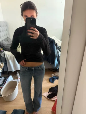 Ljusblå bootcut jeans med låg midja - Säljer ett par ljusblå jeans med bootcut-modell och låg midja. Jeansen har klassisk femficksdesign och stängs med knapp och dragkedja. Perfekta för en avslappnad och trendig look.