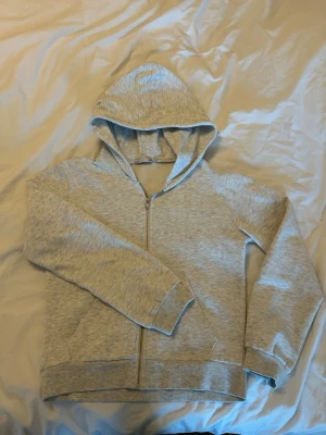 Ljusgrå zip hoodie med huva - En stilren ljusgrå hoodie med dragkedja framtill. Den är från lager 157 och är i storlek S