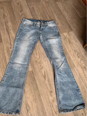 Blå bootcut jeans med slitningar - Ett par ljusblå bootcut jeans med låg midja. Jeansen har utsvängda ben och en tvättad look som ger en cool vintagekänsla. Perfekta för dig som gillar retrostil och vill sticka ut lite extra💕💕💕💕