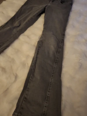 Gina tricot flared jeans - Säljer ett par grå jeans med raka ben och snygga kontrastsömmar. Jeansen har dekorativa fickor bak med lock och knapp, samt klassisk femficksmodell. Materialet är denim i bomull. Perfekta för dig som gillar en avslappnad men ändå stilren look. Aldrig använda!💕 pris går att diskutera