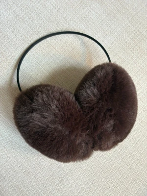 Bruna fluffiga öronmuffar - Mysiga öronmuffar i mörkbrunt fuskpälsmaterial. 