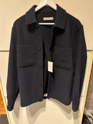 Mörkblå overshirt från Mango - Stilren mörkblå overshirt från Mango med klassisk krage, två stora bröstfickor och knäppning.   Nypris 899                                                              Aldrig använd!