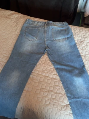 Ljusblå raka jeans med dragkedja - Ljusblå jeans med raka ben och klassisk femficksdesign. Jeansen har dragkedjegylf och knapp framtill. Materialet är denim i bomull och de har en avslappnad passform. Perfekta för en chill och stilren look. w36 l34