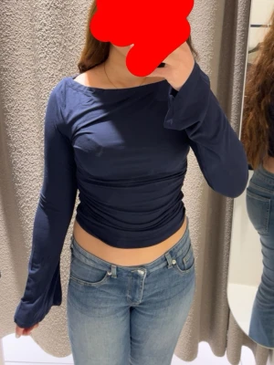 Mörkblå långärmad croppad topp - mörkblå långärmad topp med croppad passform och lätt rynkade detaljer längs sidorna.  Endast använd några gånger