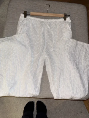 Vita broderade linnebyxor Gina Tricot - Säljer ett par vita linnebyxor från Gina Tricot i storlek XS. Byxorna har broderade blommor, resår i midjan och är luftiga med rak passform. Byxorna är mid-waist. Perfekta för en avslappnad och trendig look.