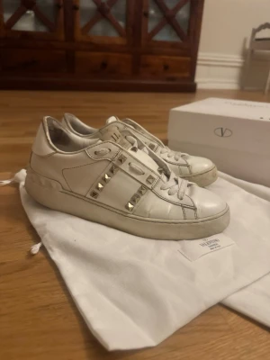 Vit Valentino sneaker med nitar - Storlek 37 men passar även för de som har 38. Man kan byta sula då denna är mycket använd. Man kan också byta skosnören. Om man har bra sko tvätt kan man dessutom få bort mer smuts på sulan. 