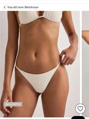 Vit bikiniunderdel med rynkad baksida - Snygg vit bikiniunderdel med enkel och stilren design. Helt oöppnad förpackning. Underdelen har smala sidor och en rynkad detalj bak som framhäver formen. I färgen cream storlek small