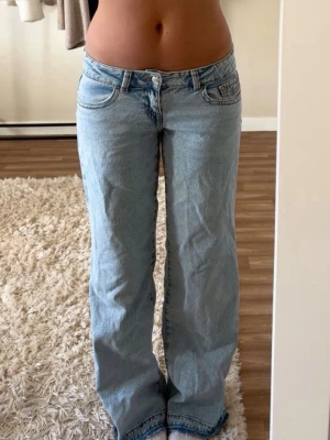 Blåa lågmidjade jeans  - Blåa lågmidjade jeans från Gina Tricot. Använda nån enstaka gång så som nya. Har sprättat upp dom nertill för att de skulle bli längre. Storlek 38 men sitter som 36. Nypris 399kr. Säljer även ett par i vit. Långa på mig som är 168cm. Tryck gärna på köp nu. 