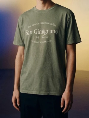 Lager 157 Grön t-shirt med San Gimignano-tryck - Snygg grön t-shirt med vitt tryck framtill där det står 'San Gimignano' och text om den italienska staden. Klassisk rund halsringning och korta ärmar. Perfekt för dig som gillar stilrena plagg med en twist. Tillverkad i mjuk bomull för skön känsla.