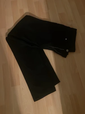 Svarta slim fit jeans - Säljer ett par svarta slim fit jeans med klassisk dragkedja och knappstängning. Jeansen har en smal passform och är tillverkade i ett mjukt material som sitter snyggt. Perfekta för dig som gillar en stilren och enkel look.