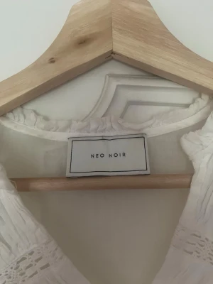 Vit volangblus från Neo Noir - Söt vit blus från Neo Noir med volangdetaljer och v-ringning i linne.  ANVÄND MAX 3 GGR! Köpt för några år sedan för 700kr🥰🥰 Står ej storlek men passar S!