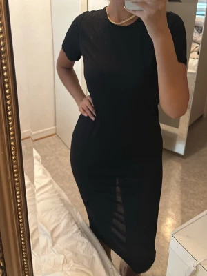Med prislapp! Svart tight midiklänning - Nypris: 199kr Svart, figurnära midiklänning med korta ärmar och rund halsringning. Klänningen har en enkel och stilren design som passar perfekt till många olika tillfällen. Tillverkad i mjukt och stretchigt material för en bekväm passform.