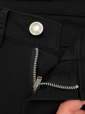 Svarta bootcut jeans från Gina Tricot - Säljer ett par svarta bootcut jeans från Gina Tricot med klassisk femficksmodell, dragkedjegylf och silverfärgade detaljer. Jeansen har några ljusare fläckar över bakfickorna, som en missfärgning tyvärr. Jeansen är väldigt lågmidjade och har ett tunt material.