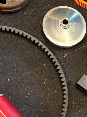  variatordelar - Säljer ett set variatordelar till moped, inklusive en svart och orange variator från Motoforce Racing samt en silverfärgad variatorskiva i metall. Perfekt för dig som vill trimma eller uppgradera din moped.