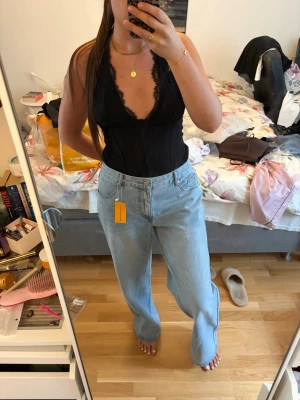 Ljusblåa baggy jeans - Säljer ett par ljusblåa baggy jeans med hög midja och raka ben. Jeansen har klassisk femficksdesign och är tillverkade i denim. Perfekta för en avslappnad och trendig look. Dem är lite för stora för mig. Har aldrig använt.