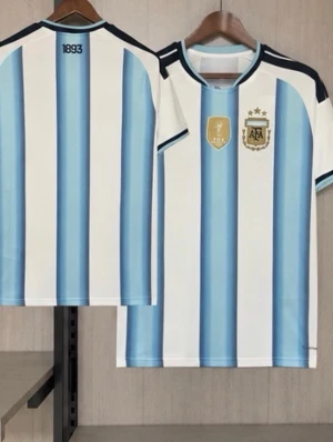 Argentina fotbollströja blåvit - Säljer en klassisk Argentina fotbollströja med vertikala blå och vita ränder, svarta detaljer på axlar och ärmslut samt AFA-emblem och tre stjärnor på bröstet. Tröjan har rund hals och är tillverkad i ett lätt, ventilerande material.