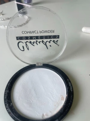 Claudia Cosmetics Compact Powder - Kompaktpuder från Claudia Cosmetics i en rund plastförpackning med transparent lock. Pudret är vitt och har en matt finish, perfekt för att fixera foundation och ge en jämnare hudton. Enkel att ta med i väskan tack vare den smidiga storleken.