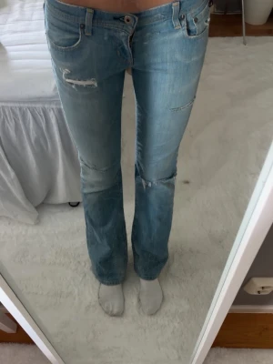 Ljusblå slitna bootcut jeans polo jeans  - Säljer ett par ljusblå bootcut jeans med slitningar och hål från början från polo jeans (Ralph lauren)  Jeansen är lågmidjade och köpta på Vinted för ca ett halvår sedan. Dom är i storlek 2 men i vanliga storlekar passar dom XS/34