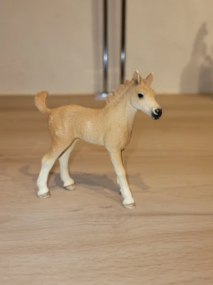 Ljusbrun hästfigur från Schleich - Säljer ett ljusbrunt föl från Schleich. Figuren har detaljerad man, svans och svarta detaljer på mulen. Perfekt som dekoration eller leksak för hästälskare.