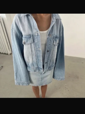 ljusblå jeansjacka - Säljer en ljusblå jeansjacka med klassisk krage, knappstängning framtill och två bröstfickor med lock. Jackan har en avslappnad passform och är perfekt för en trendig streetstyle-look. Passar dig som gillar en casual vibe.Super fin till vår/sommar🥰