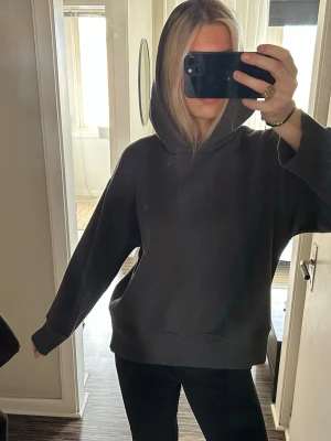 Oversized grå hoodie - Säljer en oversized grå hoodie med huva och breda muddar. Hoodien har en avslappnad passform och är perfekt för en chill och stilren look. Materialet känns mjukt och skönt mot huden. Passar perfekt till jeans eller leggings.