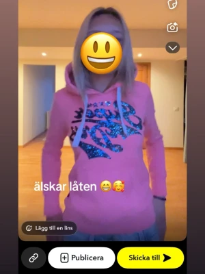 Rosa Superdry hoodie med glittertryck - Snygg rosa hoodie från Superdry med stort glittrigt logotryck i blått på bröstet. Hoodien har huva med vita snören och en klassisk magficka. Perfekt för en chill och trendig look.