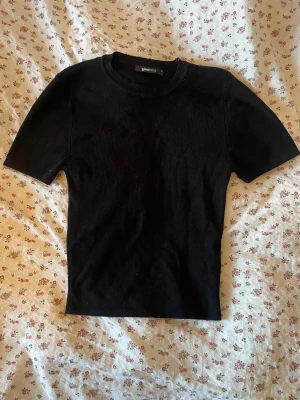 Svart topp från Gina Tricot - En enkel och skön svart topp från Gina Tricot! Modellen har rund halsringning och korta ärmar. Perfekt att matcha med jeans eller kjol! Använd väldigt få gånger så den ser ut som ny 🖤