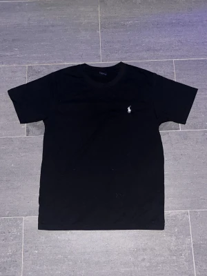Svart t-shirt från Ralph Lauren - Svart RL tisha oanvänd eftersom den är för stor så har aldrig kunnat använda och vill bli av med den nu så jag kan köpa i rätt storlek