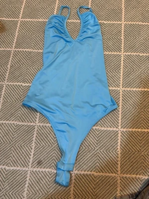 Blå body ALDRIG ANVÄND!! - Jag har aldrig använt den! Men en fin body. Man kan ändra på banden så det går o ha den på olika sätt.