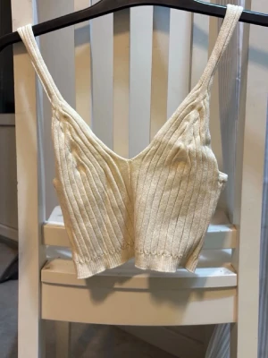 Ribbat linne beige - Ett beige ribbat linne. Aldrig använt!